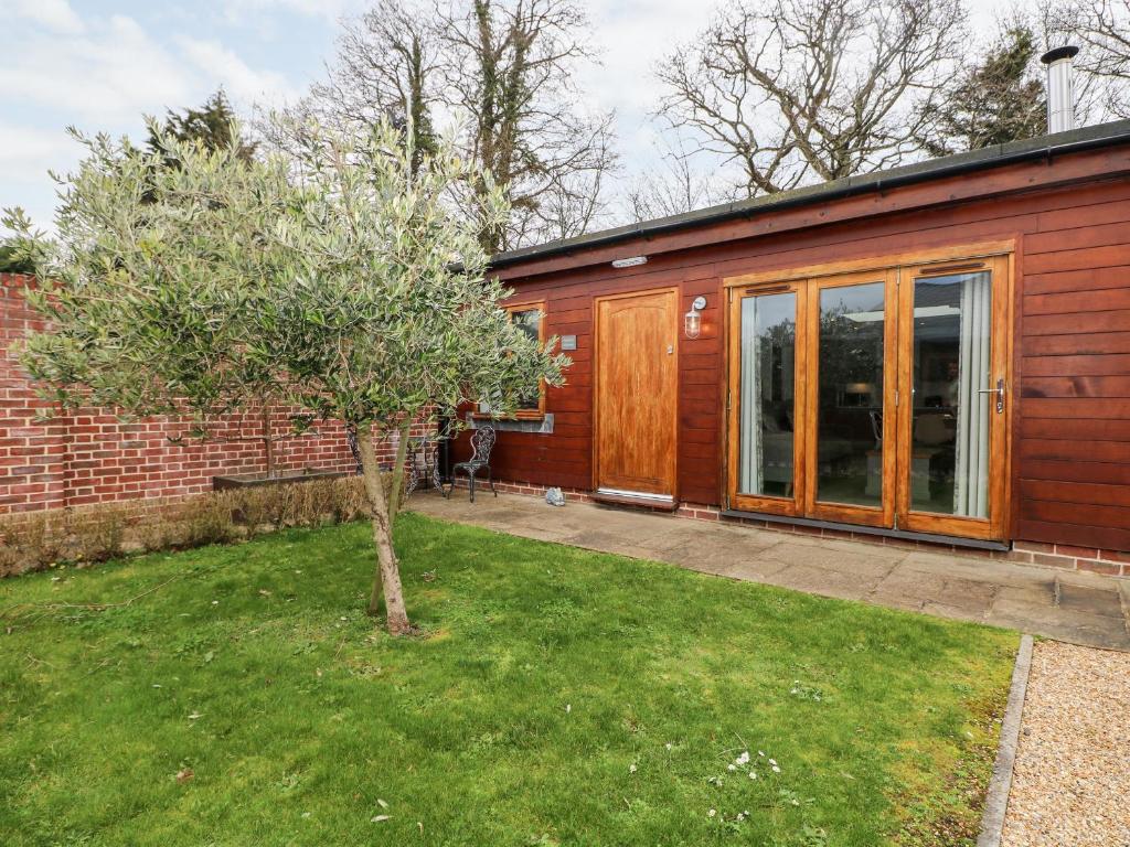 een rood huis met een boom in de tuin bij Rabbit's Warren in Warsash