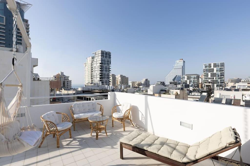 Elle comprend un balcon meublé offrant une vue sur la ville. dans l'établissement Boho Vibe - Penthouse, à Tel Aviv