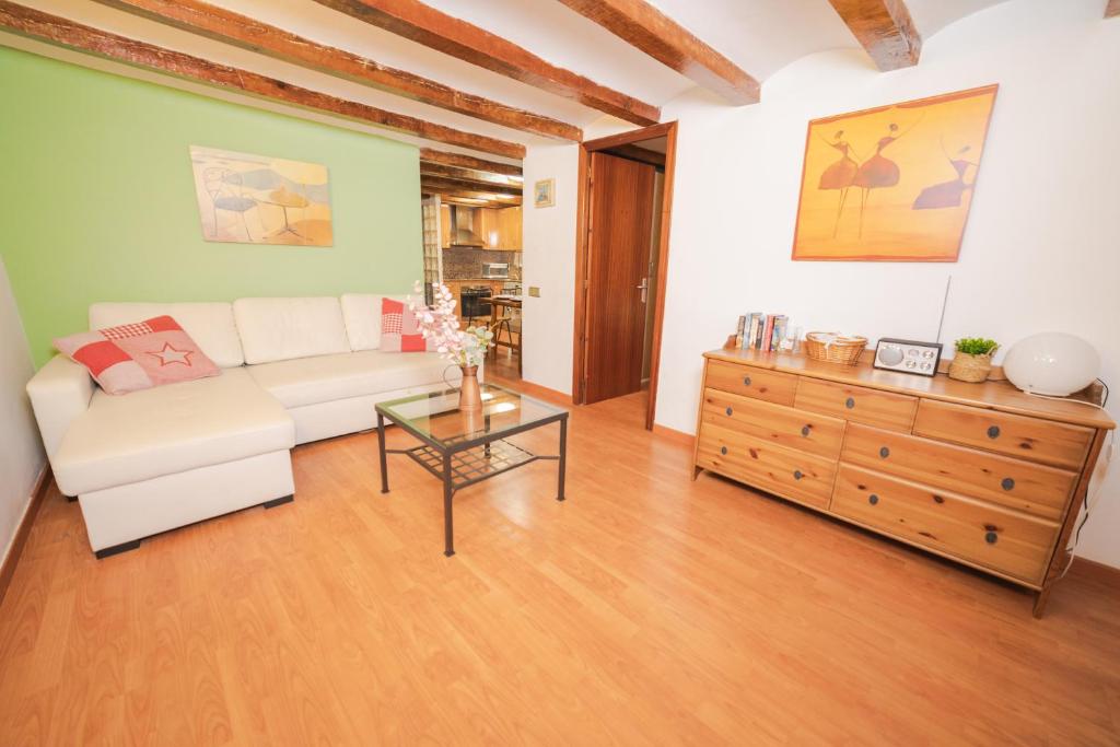 バルセロナにあるRustic Poble Sec Apartmentのリビングルーム(白いソファ、ガラスのテーブル付)