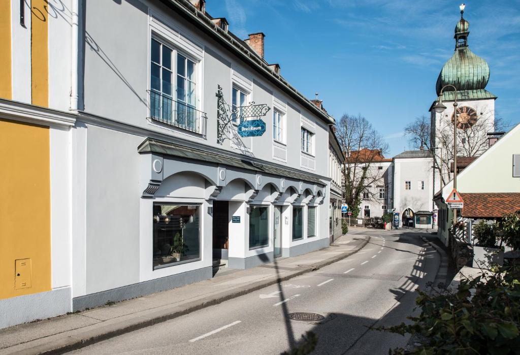 una calle con edificios blancos y una torre de reloj en Apartments Zum Ybbsturm en Waidhofen an der Ybbs