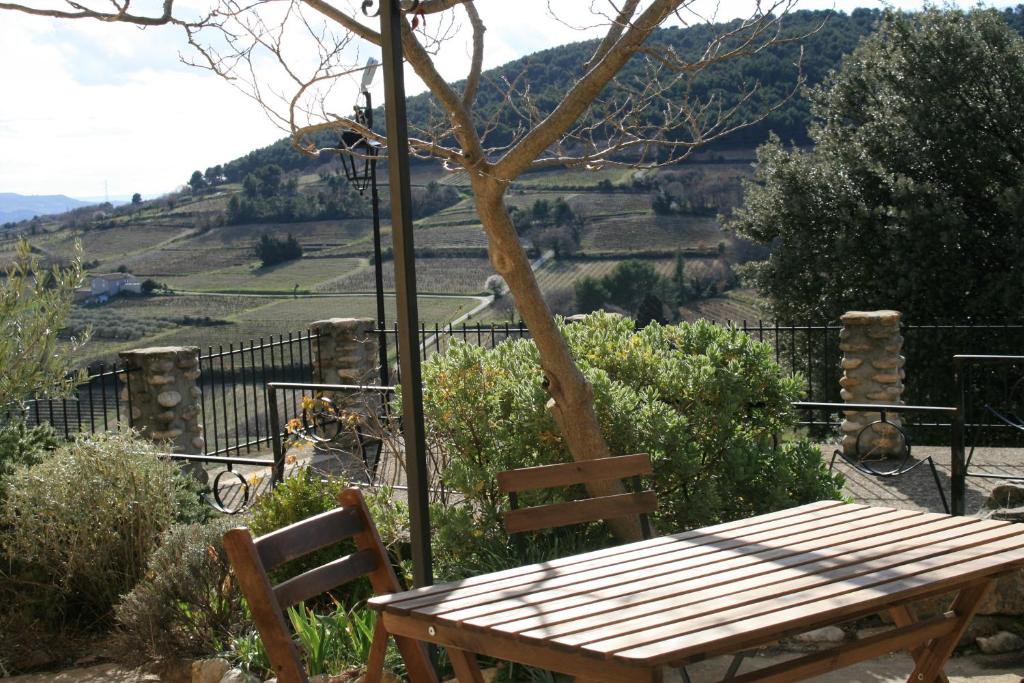 d'une table et de chaises en bois avec vue sur une colline. dans l'établissement Grand Studio en Drôme Provencale, à Vinsobres