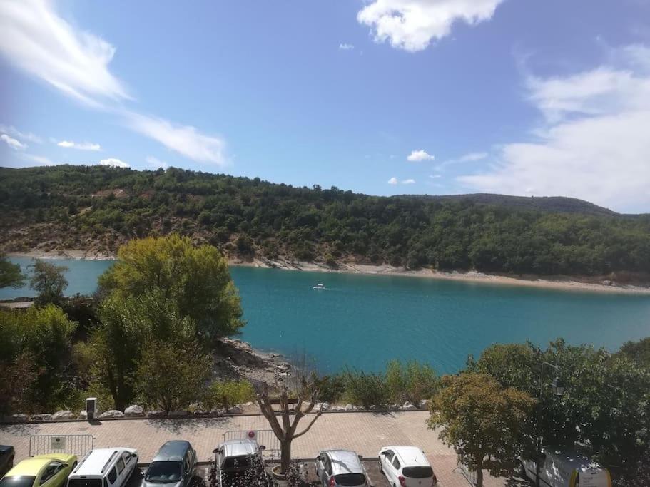 un groupe de voitures garées à côté d'un lac dans l'établissement Appartement face au lac, à Bauduen