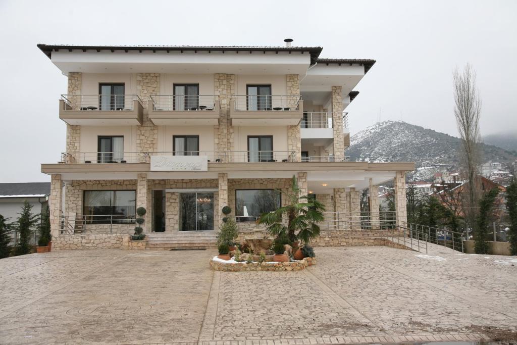 un gran edificio blanco en la cima de una montaña en Diamond River Resort & Spa, en Kastoria