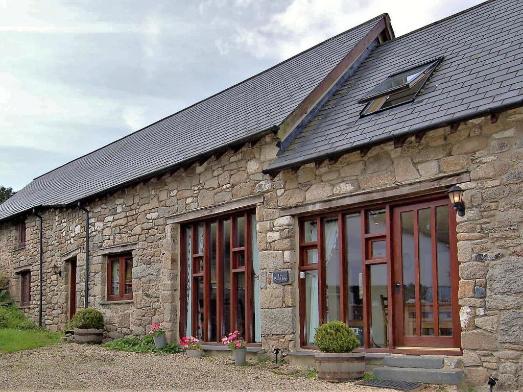 a stone building with windows and a roof at The Bolthole in Okehampton