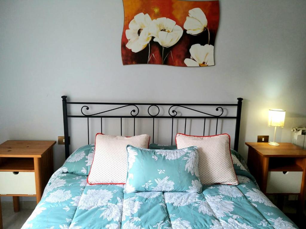 una camera da letto con un letto con due cuscini e un quadro di Figli di Decebalo a Valmontone