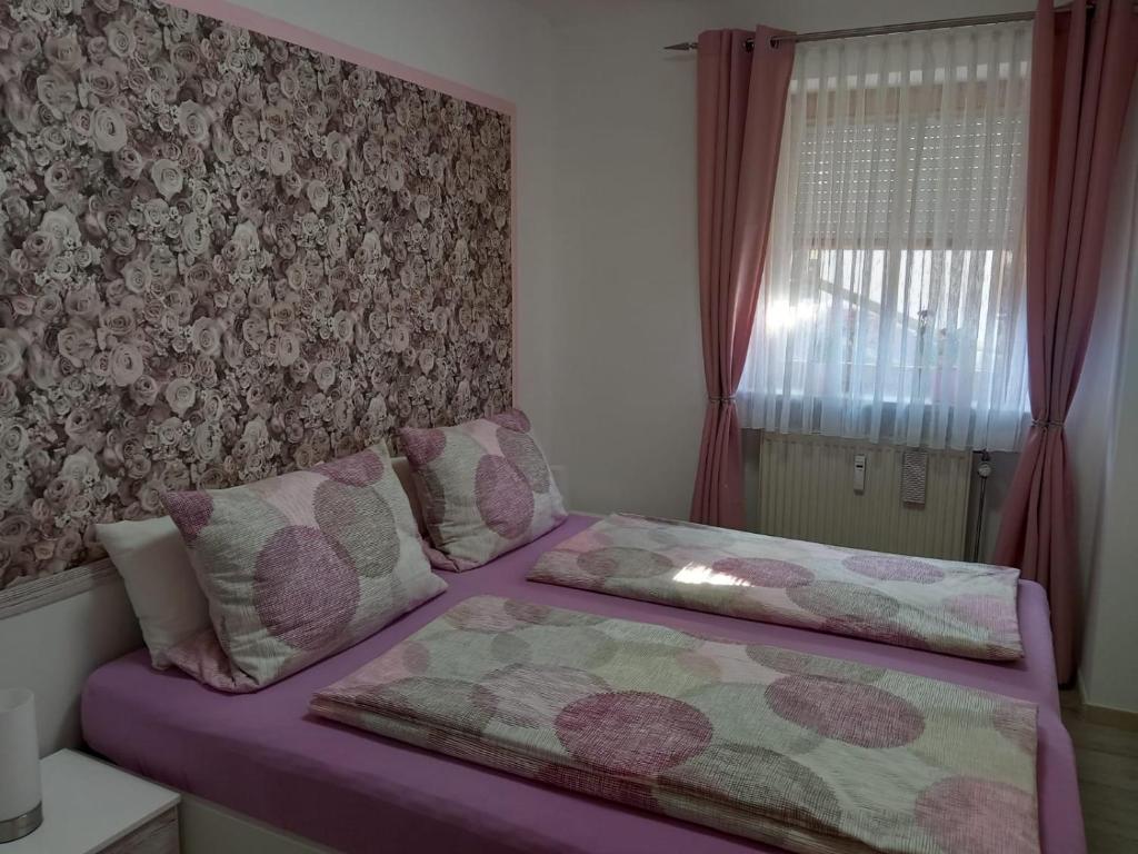 ein Schlafzimmer mit einem lila Bett mit einer Wand in der Unterkunft Landhaus Rißbachtal in Bodenmais