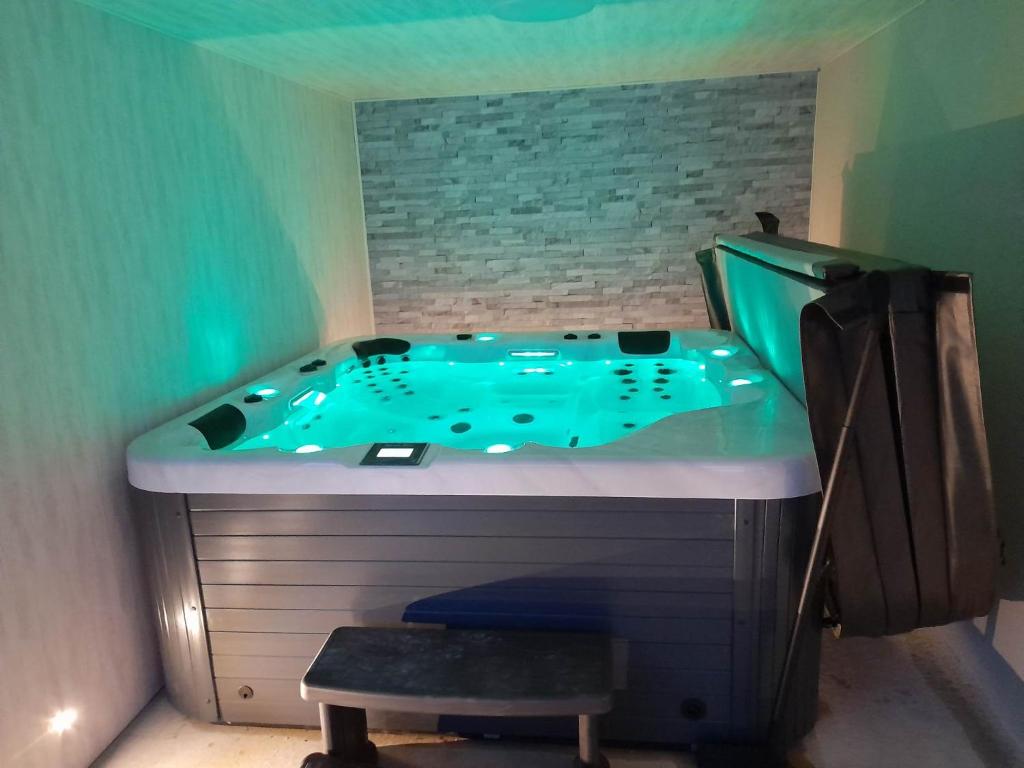 eine Whirlpool-Badewanne in einem Zimmer mit Hocker in der Unterkunft bien-être de l'Aveyron in Aguessac