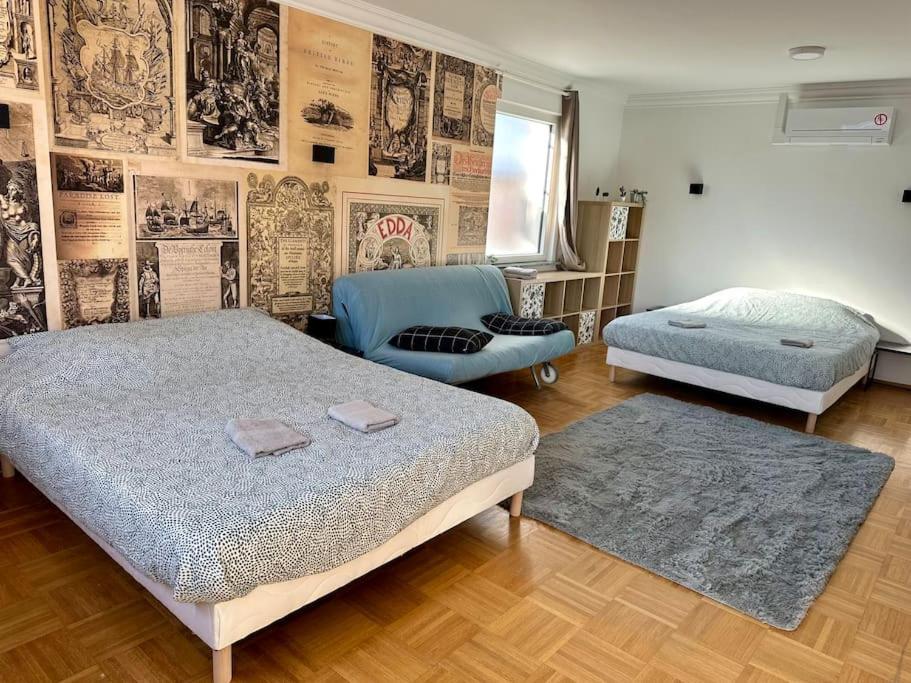 ein Schlafzimmer mit 2 Betten, einem Sofa und einem Stuhl in der Unterkunft Au coin de la rue in Rhinau