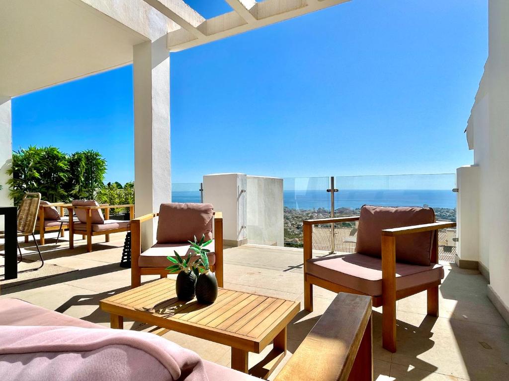 a patio with chairs and a view of the ocean at Bayview - Unique Top modern duplex penthouse with sea views and a private hot tub by Solrentspain in Benalmádena