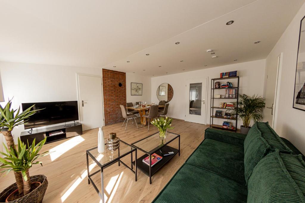 a living room with a green couch and a table at BONNYSTAY Landshut Monument in Landshut