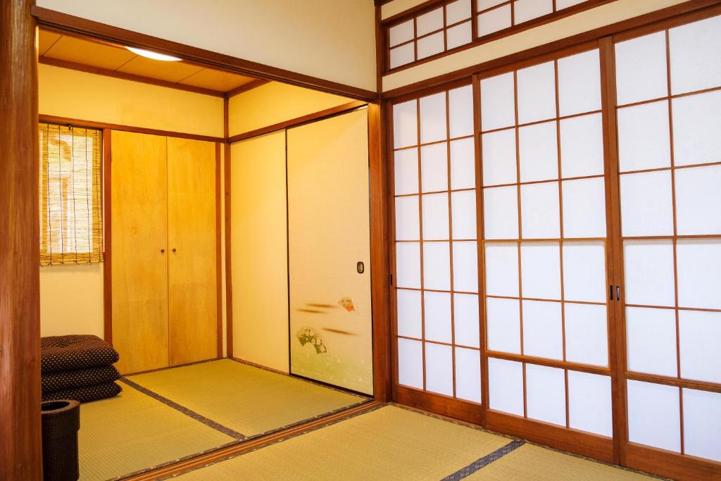 een lege kamer met een deur en een kamer met glas bij 伊豆の宿　静海 in Ito