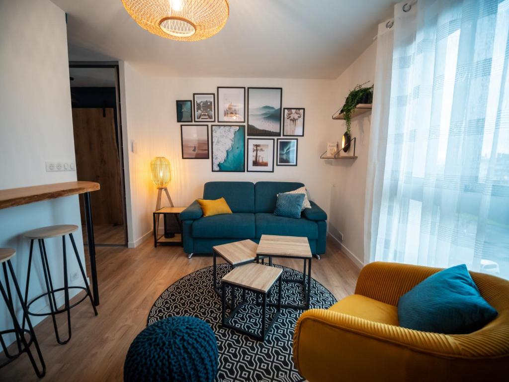 - un salon avec un canapé bleu et une table dans l'établissement HESPERIE Thermes, à Chamalières