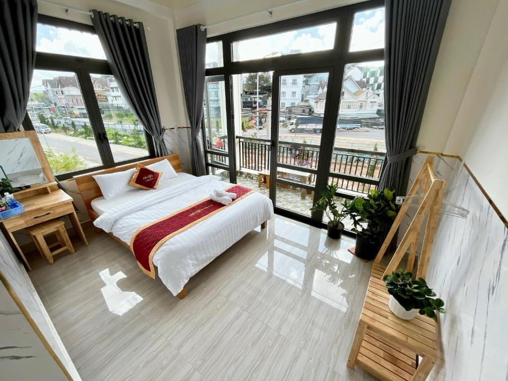 a bedroom with a bed and large windows at Ánh Vân Villa hotel in Da Lat