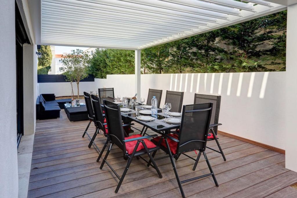 einen Esstisch und Stühle auf einer Terrasse in der Unterkunft Appartements Supérieurs in Saint-Aygulf