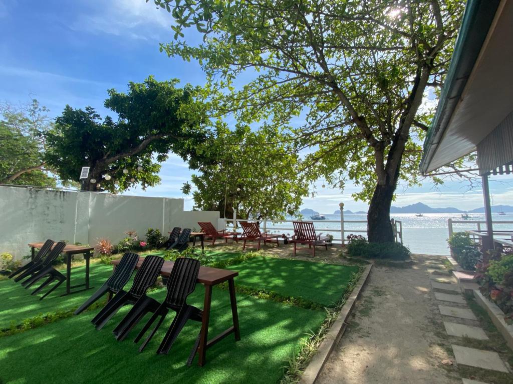 a patio with chairs and a table with a view of the water at Fabregas Beach Cottages in El Nido