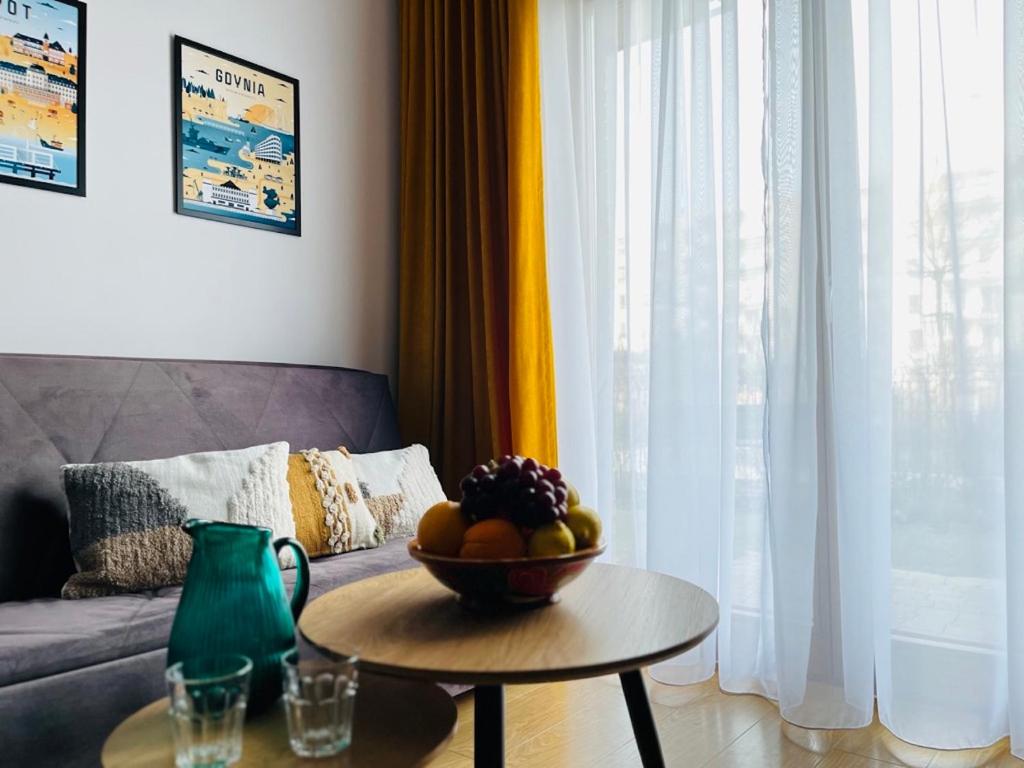 a living room with a bowl of fruit on a table at Apartament Starowiejska 54 in Gdańsk