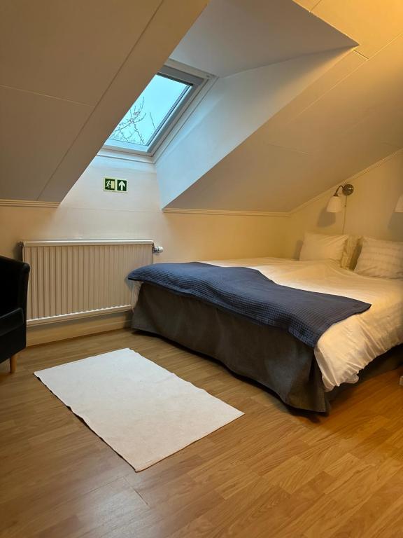 a bedroom with a large bed and a skylight at Trollhättans Bed and Breakfast in Trollhättan