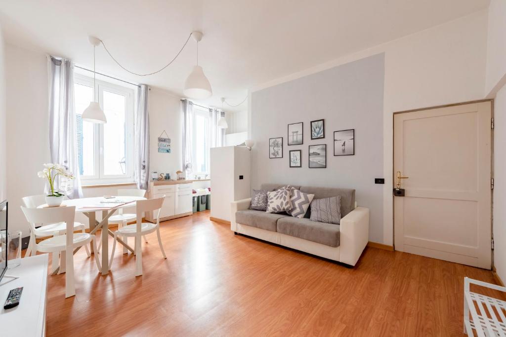 ein Wohnzimmer mit einem Sofa und einem Tisch in der Unterkunft MAZZINI 12- Appartamento centrale con posto auto privato-wifi-aria condizionata in Rapallo