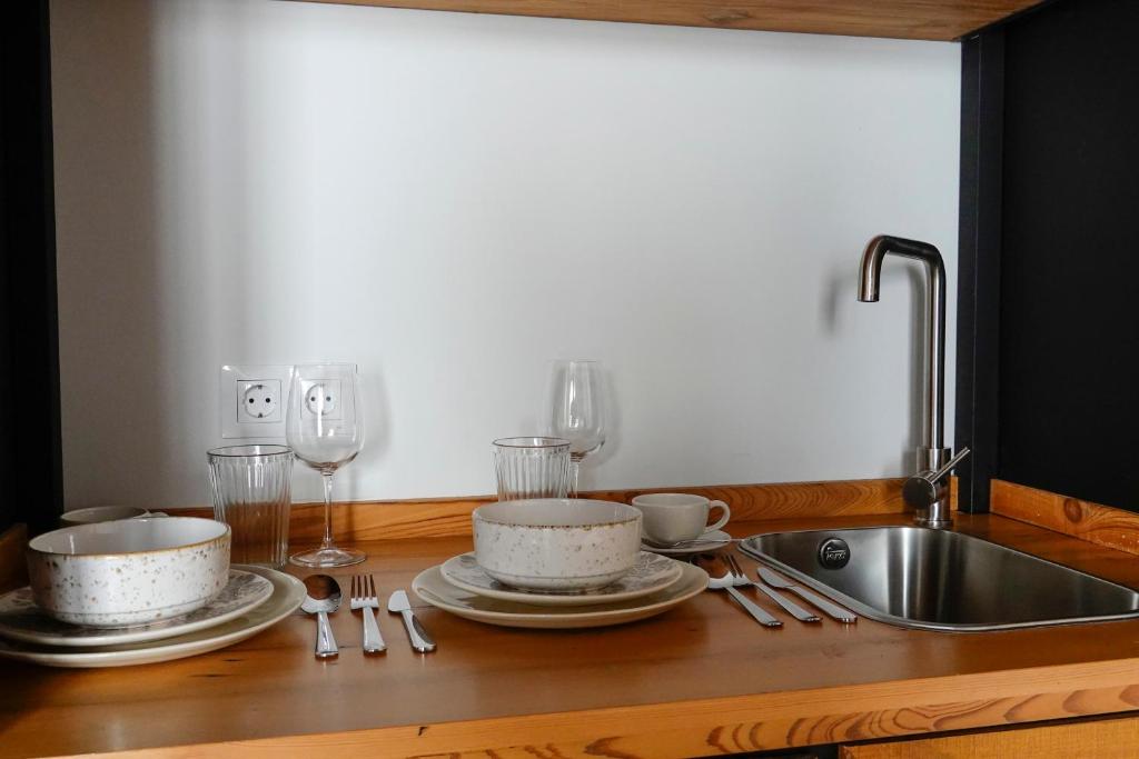 eine Küchentheke mit Spüle, Tellern und Gläsern in der Unterkunft Hospederia Santa Clara in Utrera