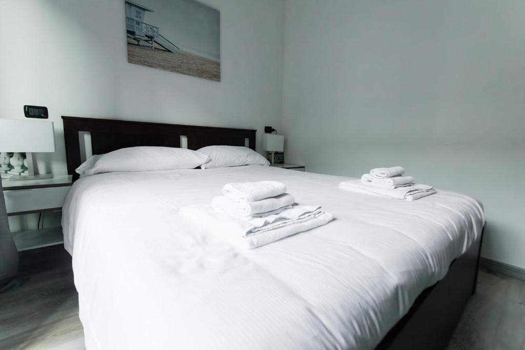 uma cama branca com toalhas por cima em Bella Camelia - Lago di Como em San Siro