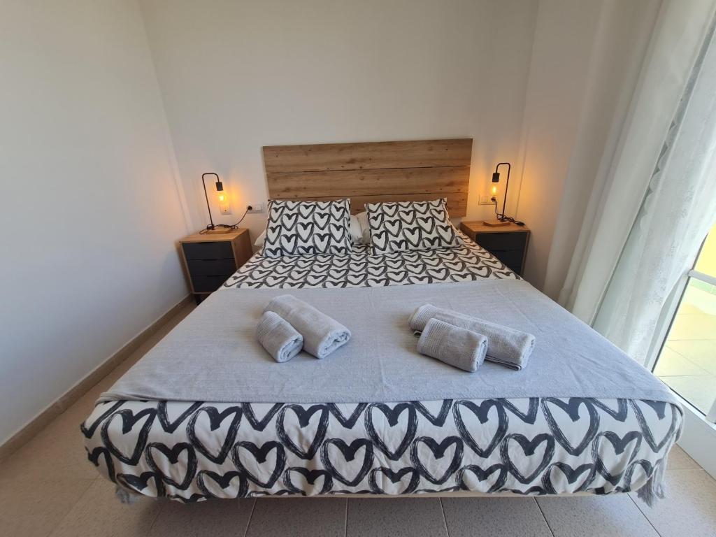 a bedroom with a large bed with two pillows at We Fuerteventura in Caleta De Fuste