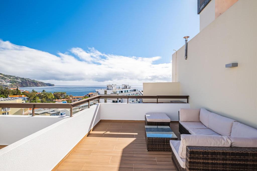 d'un balcon avec un canapé et une vue sur l'océan. dans l'établissement Apartamento Casa Branca 360, à Funchal