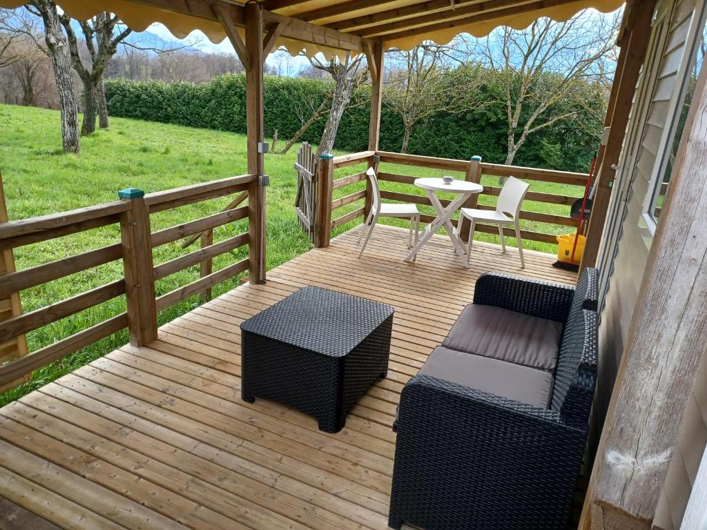 une terrasse en bois avec une table et des chaises. dans l'établissement Logement entier wifi stationnement gratuit, à Voiron