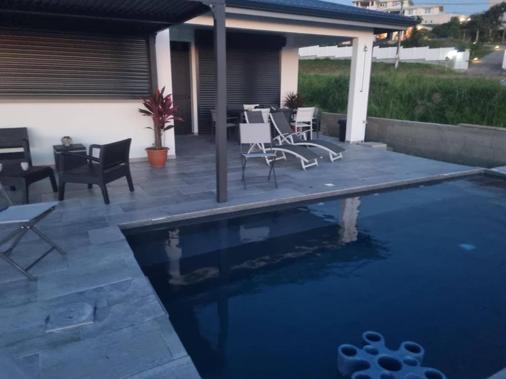 eine Terrasse mit Stühlen und einem Pool in der Unterkunft KAY SE MI in Case-Pilote