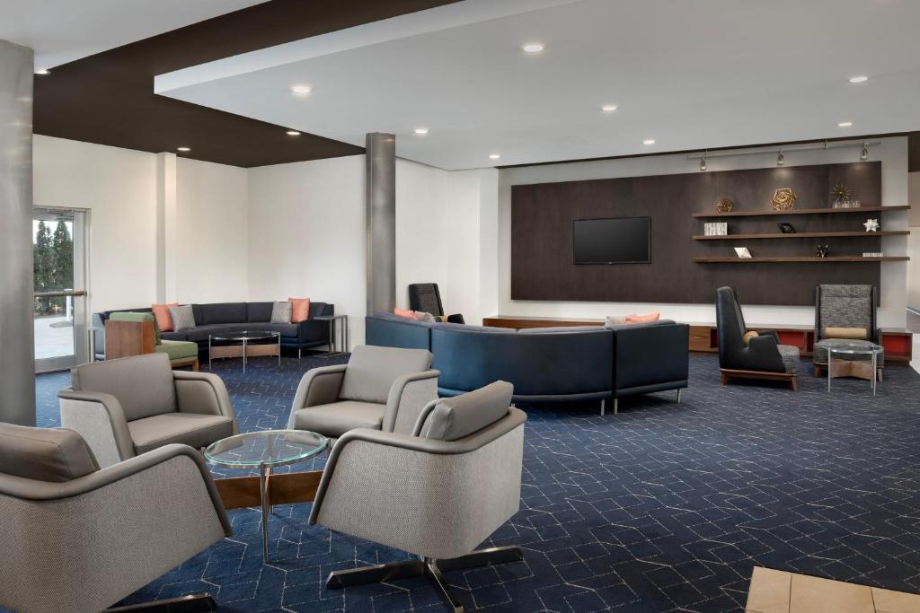 a lobby with chairs and a tv and a waiting room at Courtyard By Marriott Little Rock North in North Little Rock
