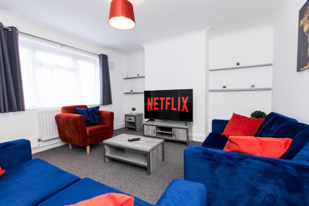 sala de estar con 2 sofás azules y TV en K Suites - Ely Road en Arksey