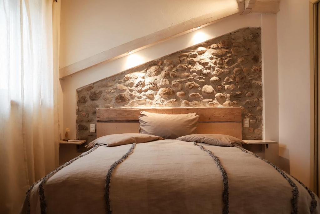 una camera da letto con un grande letto e un muro in pietra di Cà Nova B&B a Rivoli Veronese
