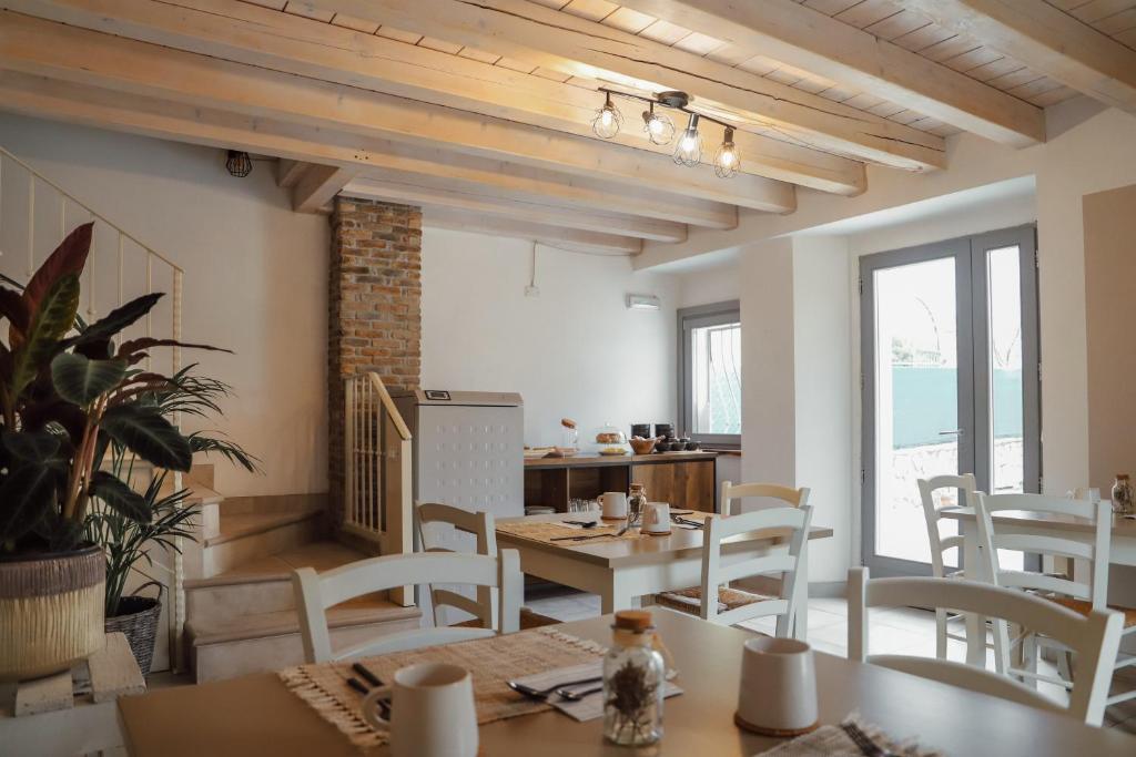 una sala da pranzo con tavoli e sedie bianche di Cà Nova B&B a Rivoli Veronese