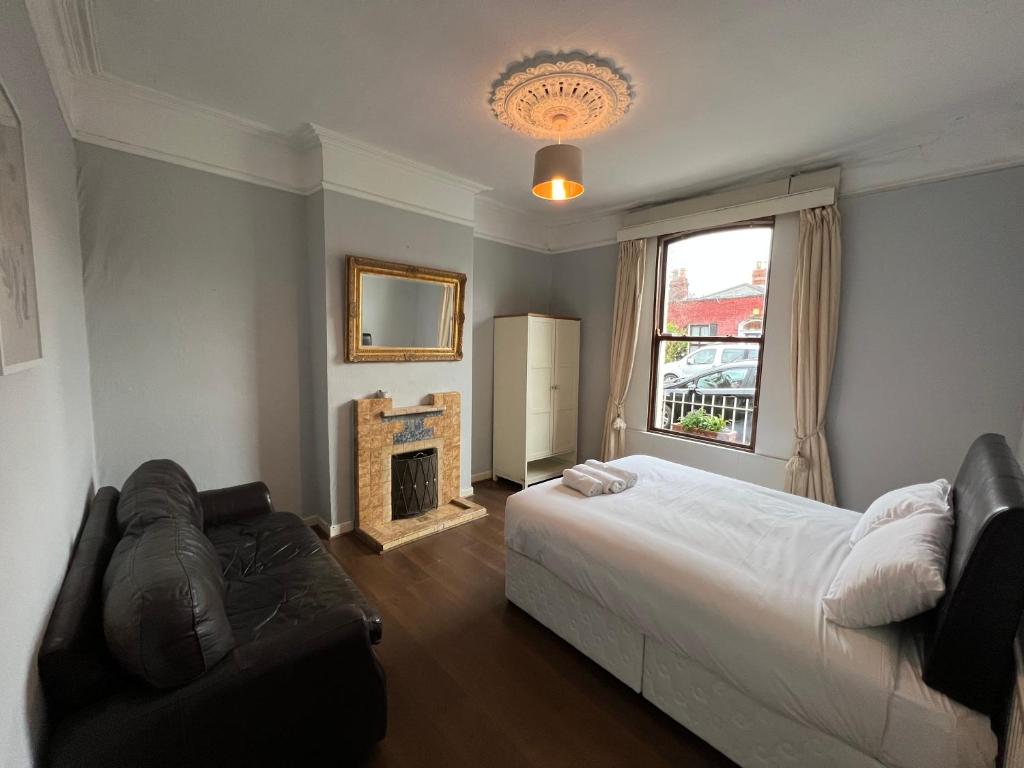 a bedroom with a bed and a couch and a fireplace at No 1 City Centre Location in Dublin