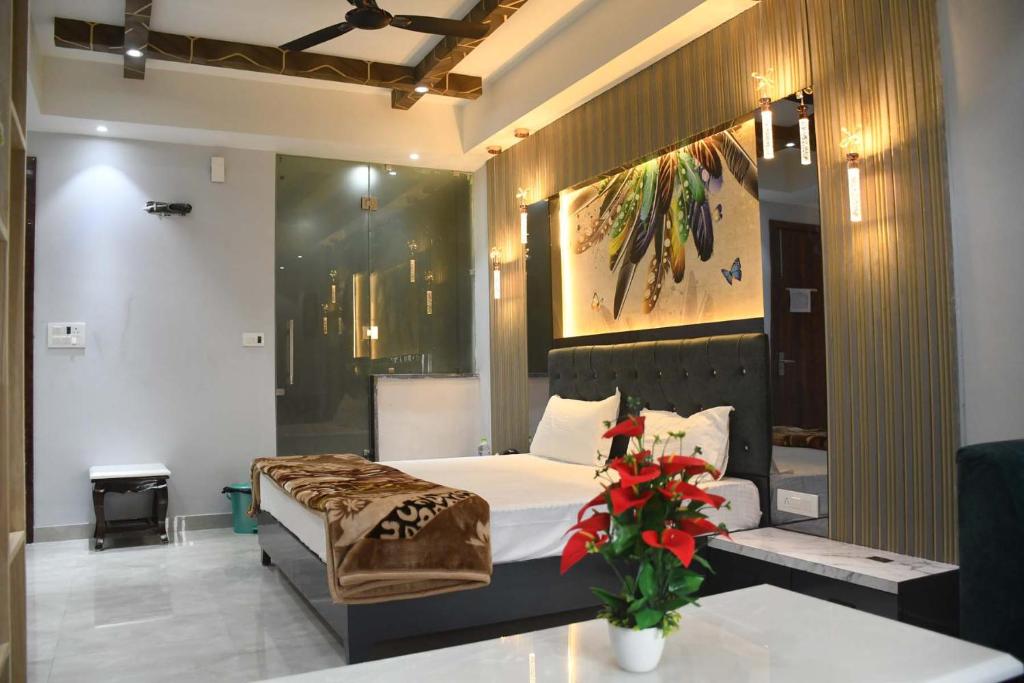 een slaapkamer met een bed en een vaas met rode bloemen bij Hotel Imperial Crown in Rewāri