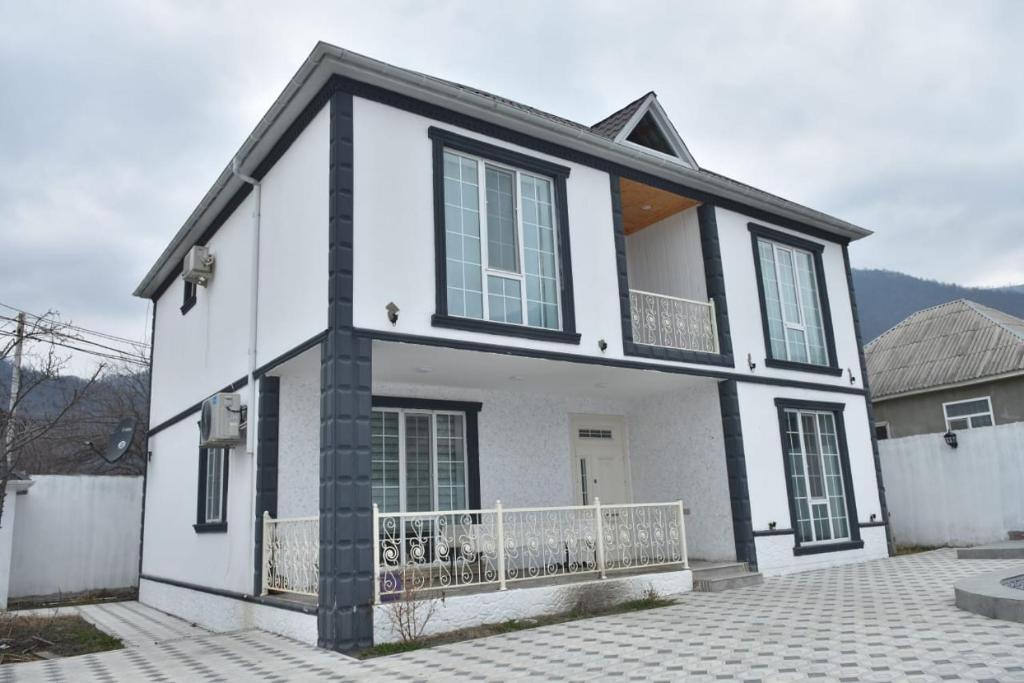 a white and black house with a fence at Gabala White House in Gabala
