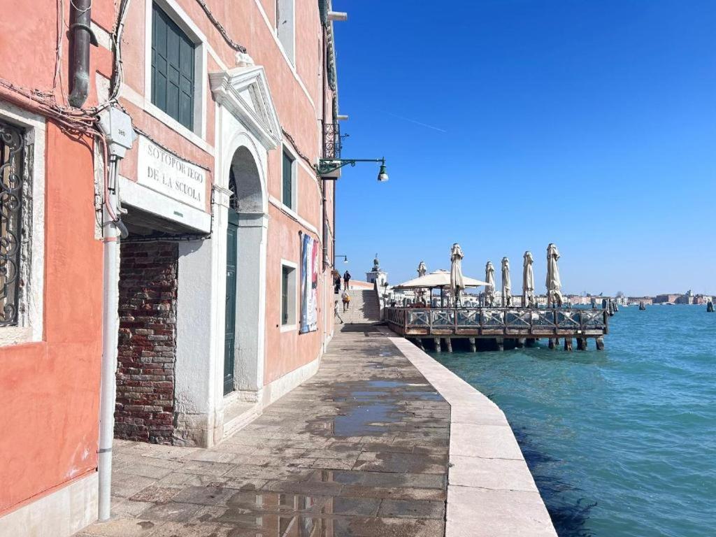 einen Bürgersteig neben einem Pier neben dem Wasser in der Unterkunft Guggenheim Luxury Suites By Bricola Apartments in Venedig