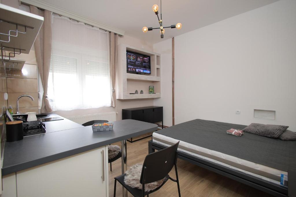 a room with a bed and a kitchen with a table at Soho in Vrnjačka Banja