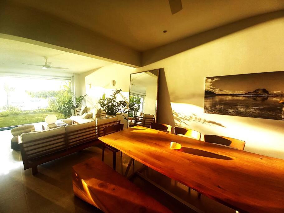sala de estar con mesa de madera y sofá en Beachfront Apartment, en Tamarin