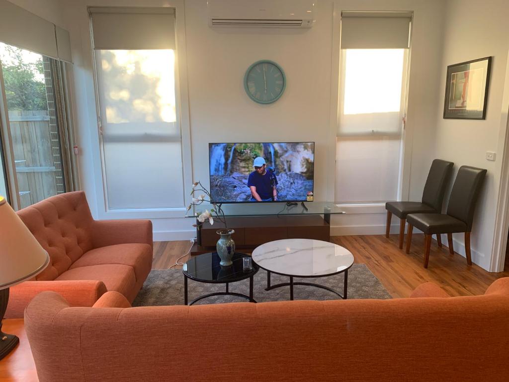 a living room with a couch and a tv at Ormond Grand Holiday Villa in Melbourne