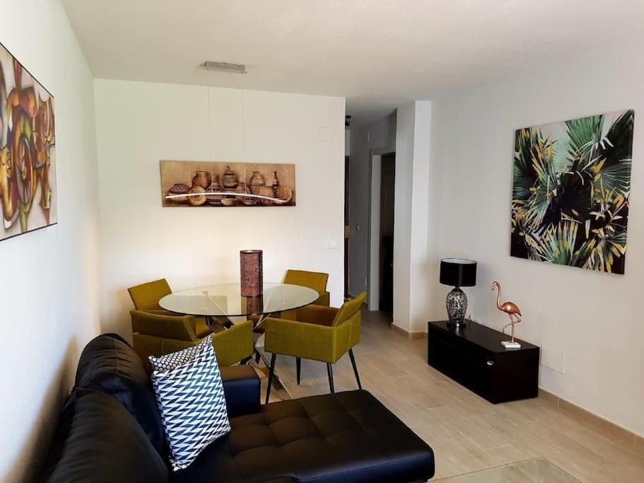 ein Wohnzimmer mit einem Sofa, einem Tisch und Stühlen in der Unterkunft Beautiful apartment in La Carihuela, Torremolinos in Torremolinos