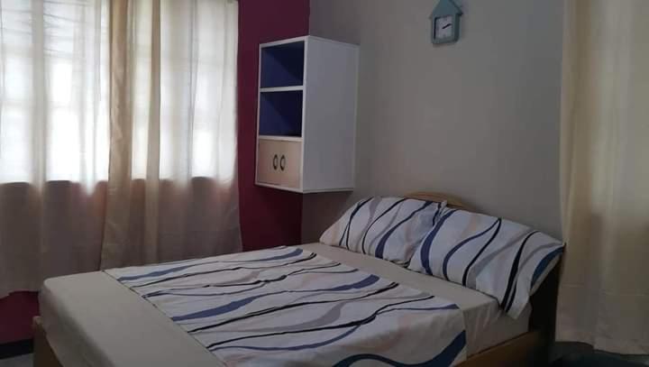 a bed sitting in a room with a window at Dion's Place in Iloilo City