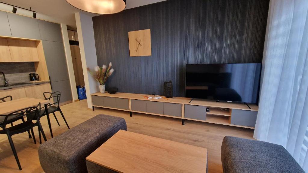 a living room with a large flat screen tv at Apartament SALONET Airport & MTP in Skórzewo