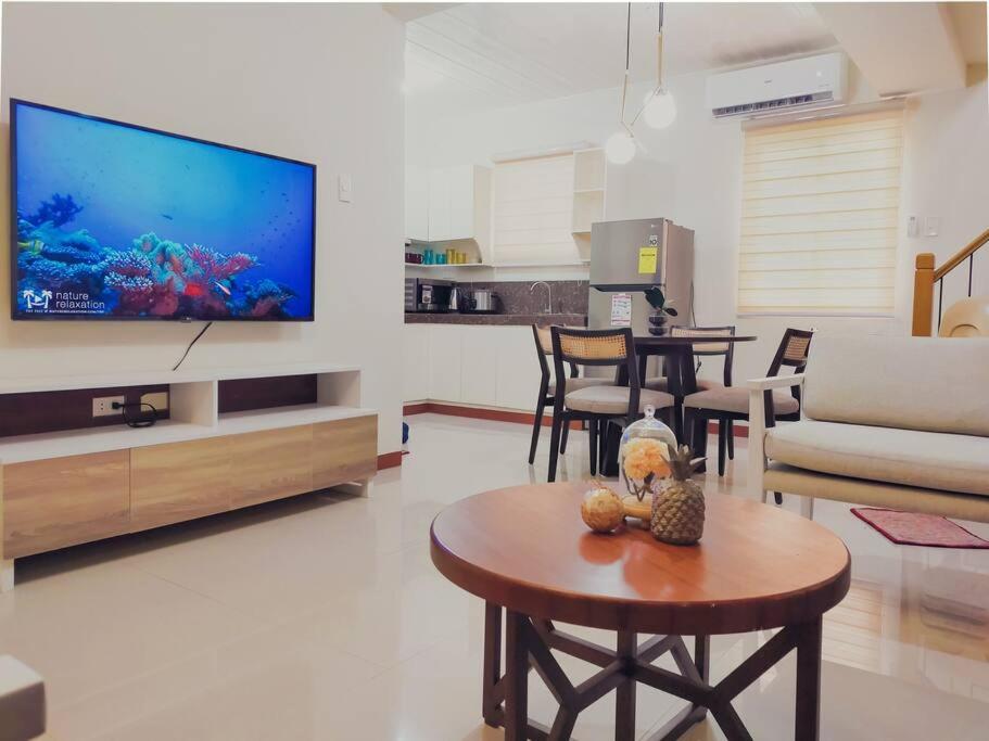 sala de estar con TV grande y mesa en Cozy 3BR Home with Garden, Pool & Modern Comforts en Ángeles