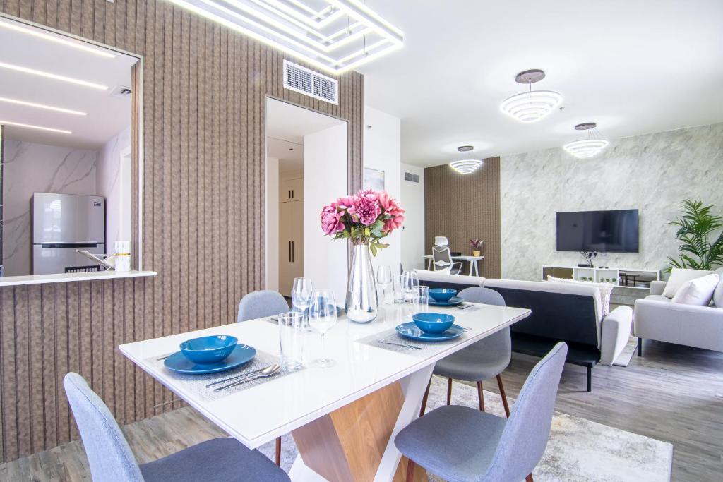 a dining room with a white table and chairs at Veluxa - Large and Stylish 1 Bed in JLT! in Dubai