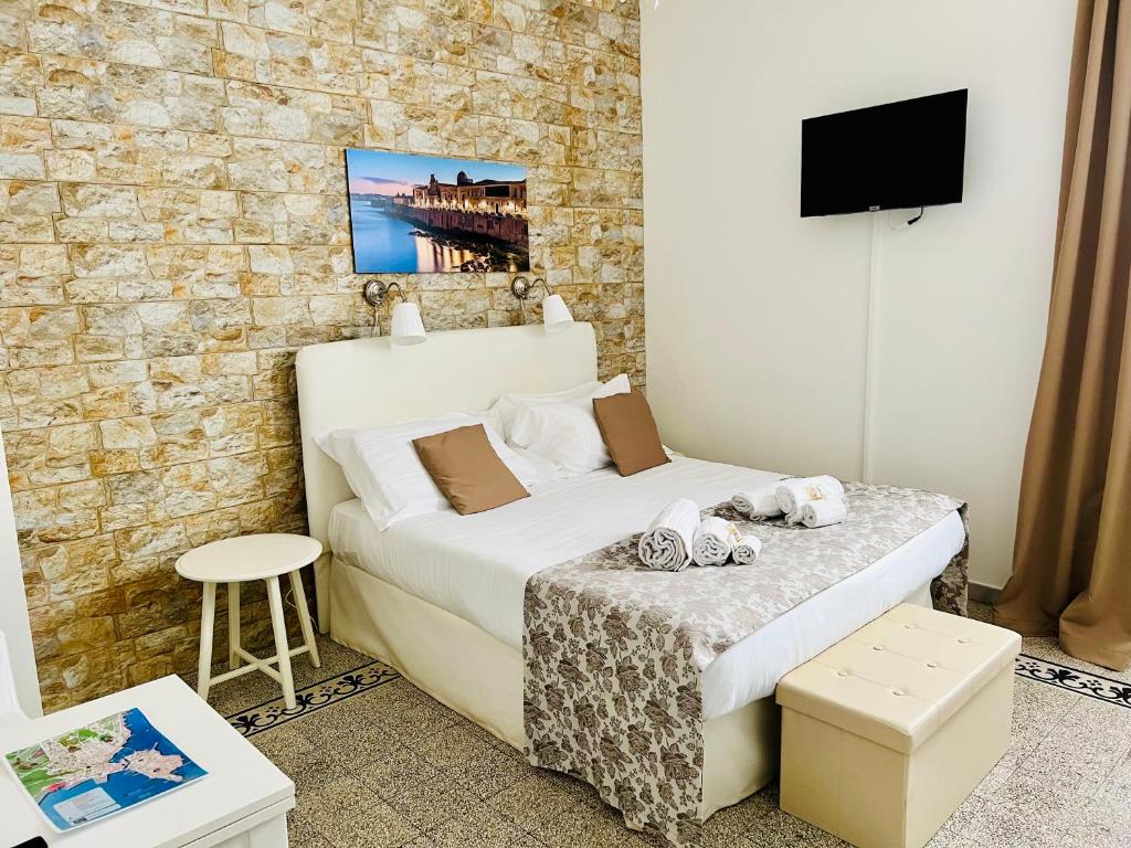 1 dormitorio pequeño con 1 cama y TV en Made in Ortigia Apartments, en Siracusa