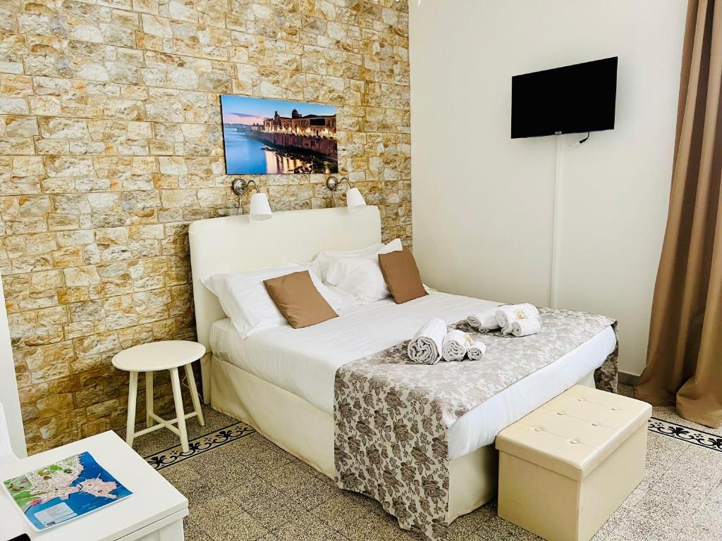 Un dormitorio pequeño con una cama y un televisor. en Made in Ortigia Apartments, en Siracusa