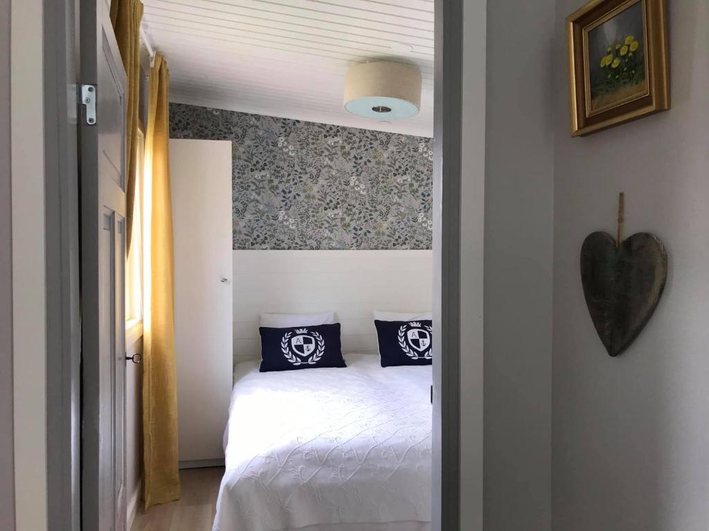 1 dormitorio con cama blanca y almohadas azules en Strandnära stuga Torsö, Sölvesborg, Blekinge skärgård, en Torsö