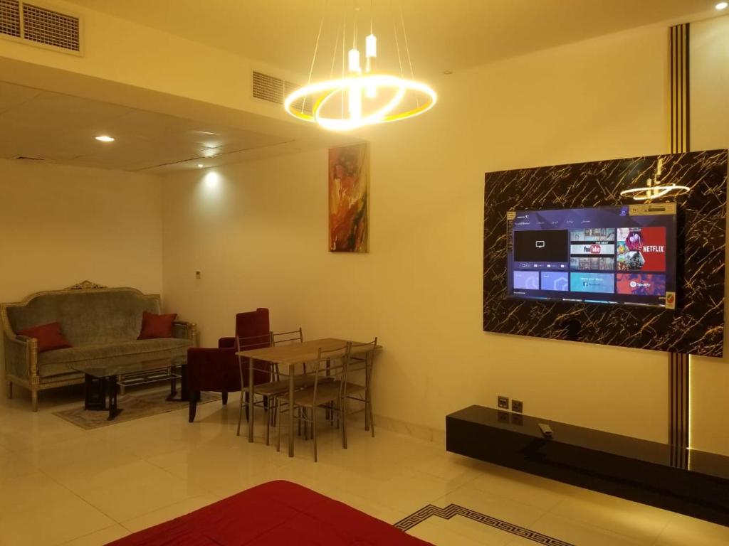 a living room with a table and a tv on the wall at Spacious 3BR Townhouse Villa in Dubai
