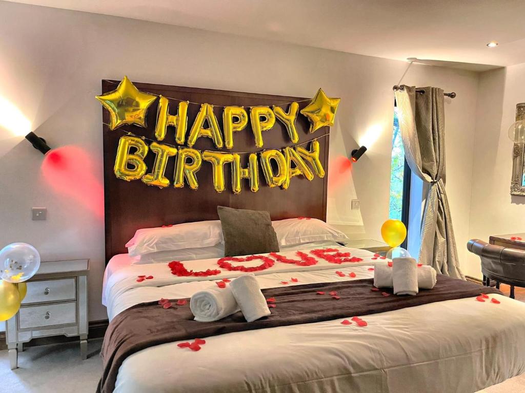 a bedroom with a happy birthday sign on a bed at BlueStone-Hot Tub-Woodlandlodges-Pembrokeshire-Tenby in Carmarthen
