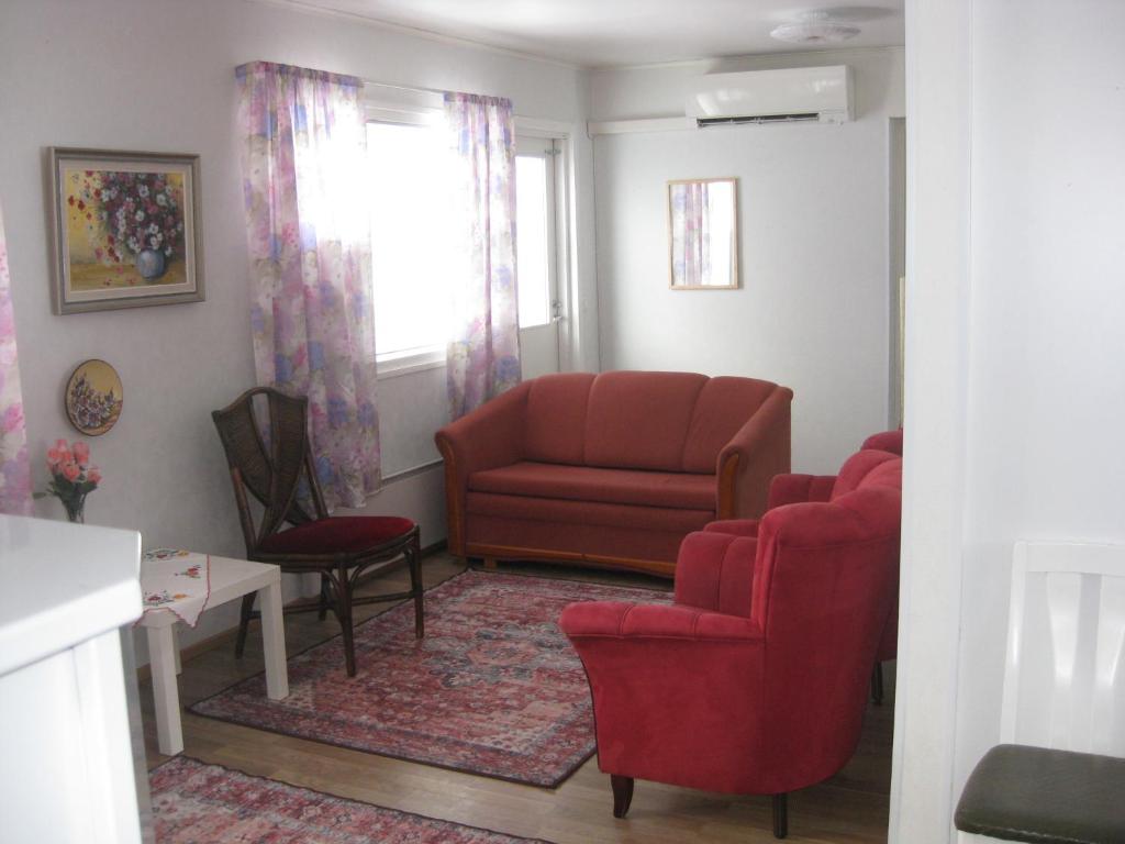 sala de estar con sofá rojo y 2 sillas en Huoneistomajoitus Hella 3C Härmä en Härmä